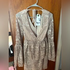 A Lacy cream colored dress, never worn, still has tags